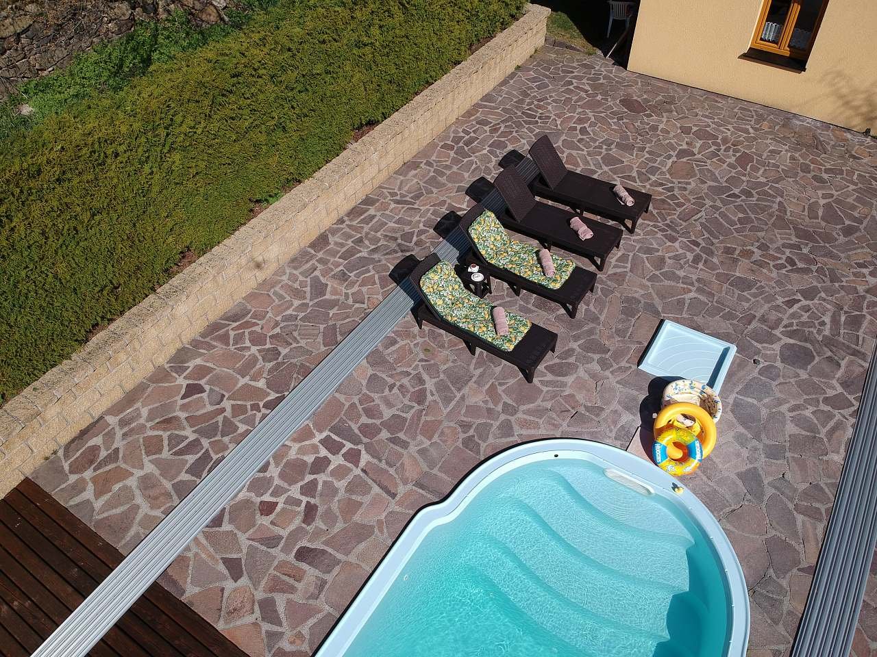 Pohled na bazén a terasu s lehátky