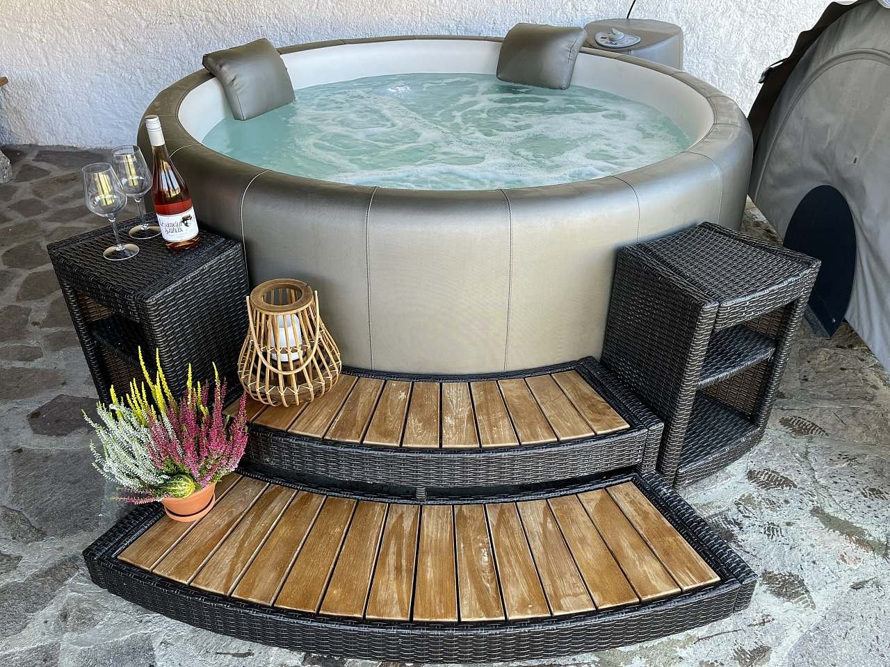 Venkovní vířivka Softub pod zastřešením u stodoly s výhledem do zahrady