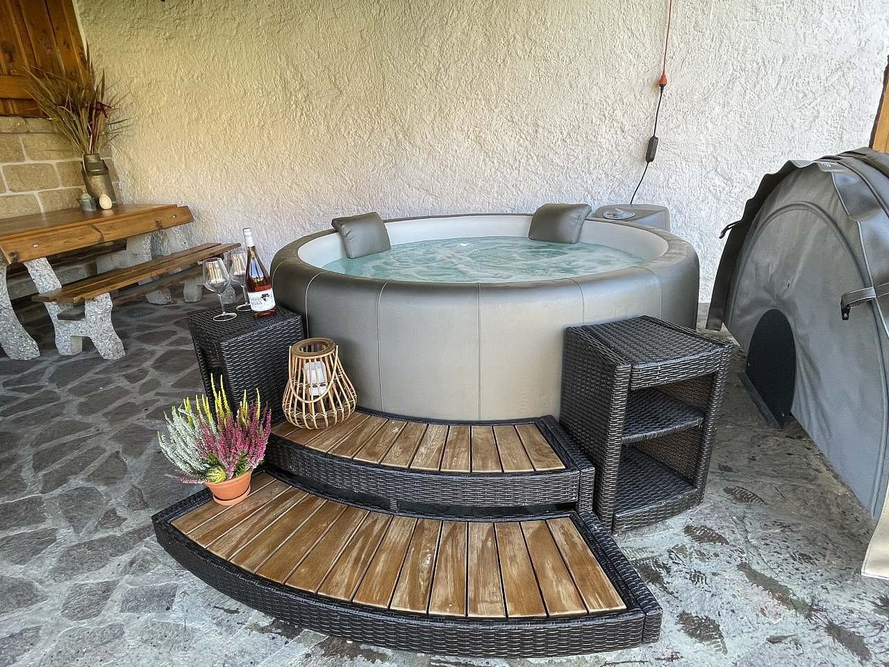 Venkovní vířivka Softub pod zastřešením u stodoly s výhledem do zahrady